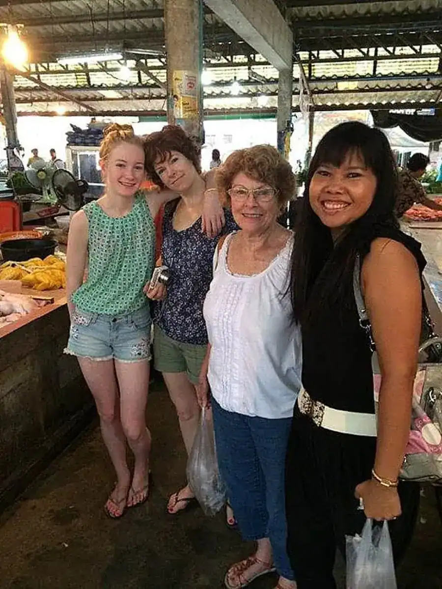 Supparin with guests during a local market visit before a private Thai cooking class in Phuket