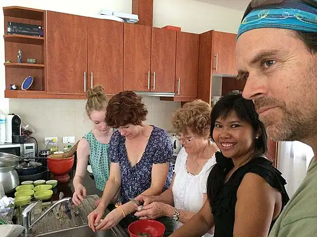 Private Thai cooking class in Phuket with Supparin teaching guests in a villa kitchen